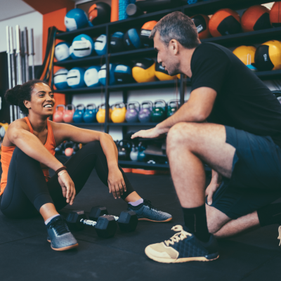 Male Personal Trainer Talking With Their Female Client.